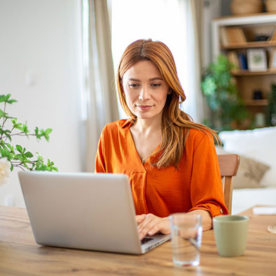 Woman in orange using a laptop